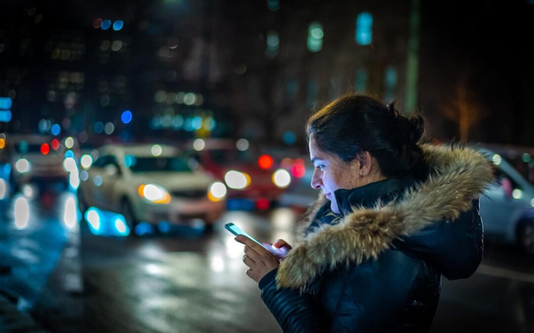 młoda kobieta zamawiająca taksówkę przez aplikację
